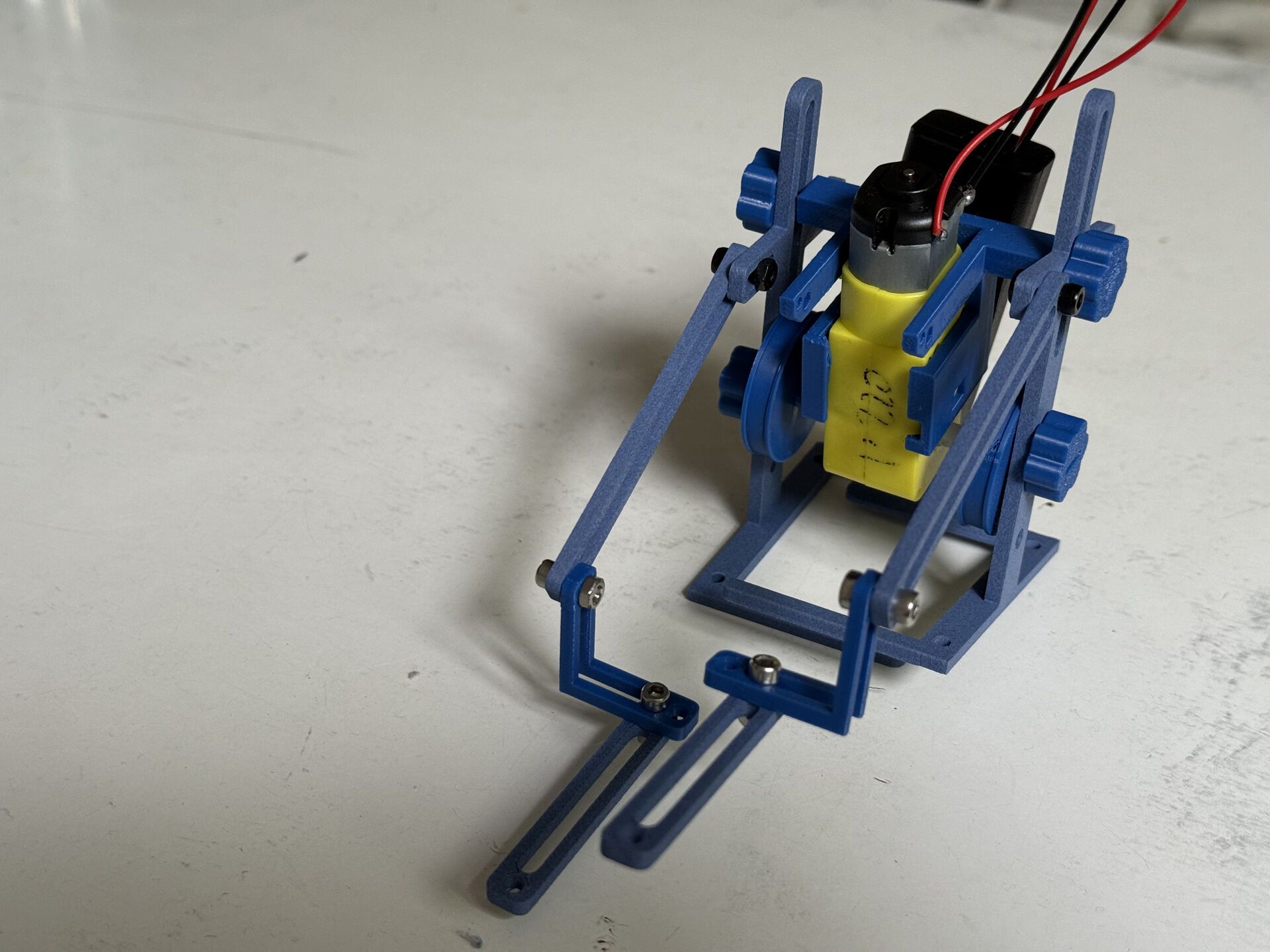 Blue 3D-printed fork lift truck robot with motor and battery